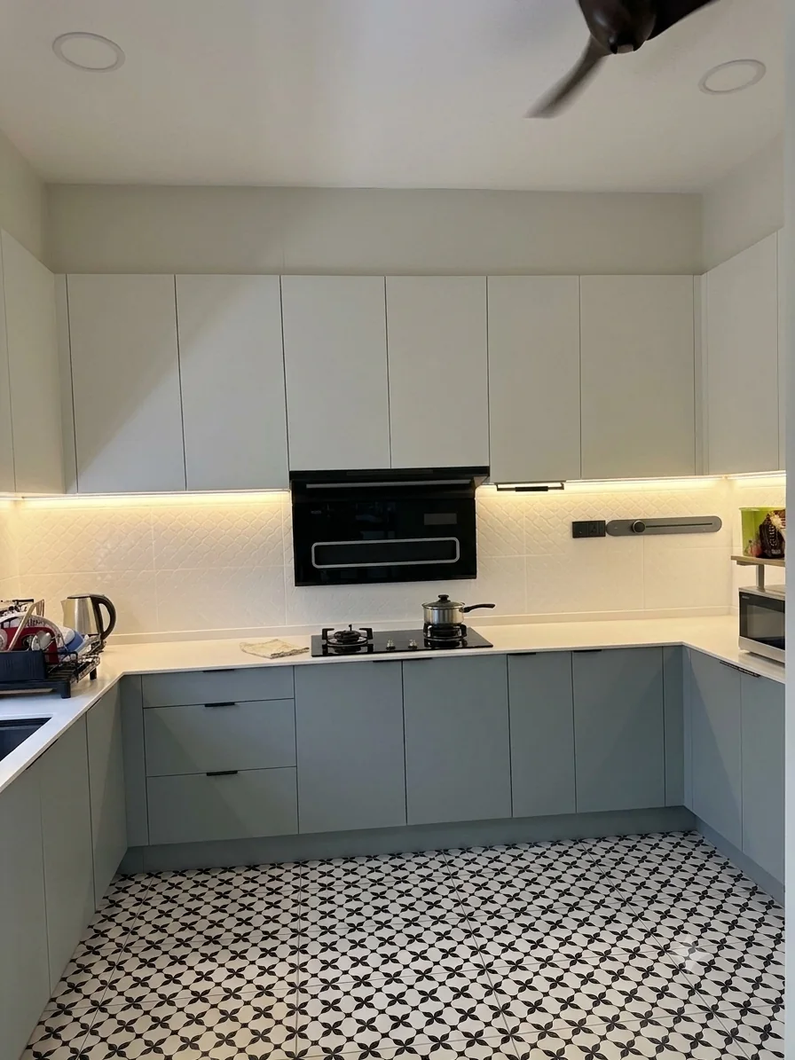 Blue-grey base cabinets and white wall cabinets in U-shaped kitchen
